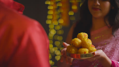 Nahaufnahme-Einer-Frau,-Die-Einem-Mann-Ladoo-Zum-Essen-Gibt,-Um-Das-Diwali-Fest-1-Zu-Feiern